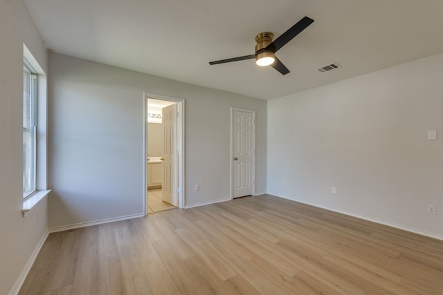 unfurnished bedroom with ceiling fan, ensuite bathroom, and light wood-type flooring