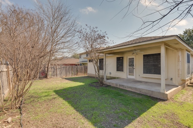 back of house featuring a lawn, ceiling fan, and a patio area