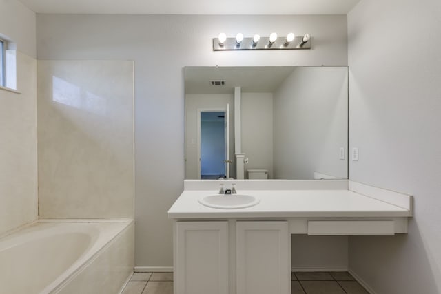 bathroom with tile patterned flooring, vanity, a washtub, and toilet