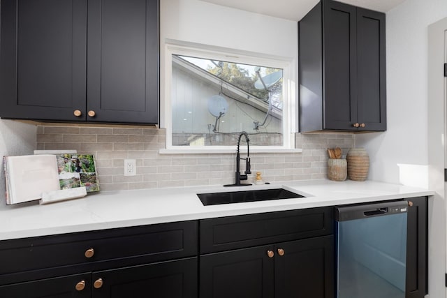 kitchen featuring decorative backsplash, sink, and stainless steel dishwasher