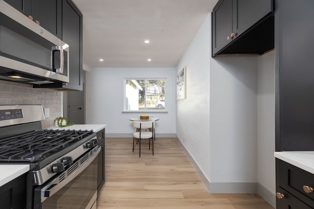 kitchen featuring backsplash, appliances with stainless steel finishes, and light hardwood / wood-style flooring