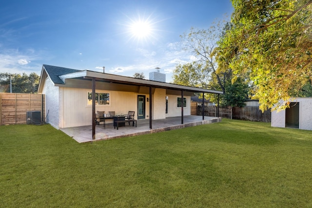 rear view of property with a yard, cooling unit, and a patio