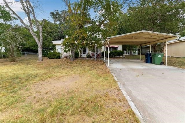 view of front facade featuring a carport and a front yard