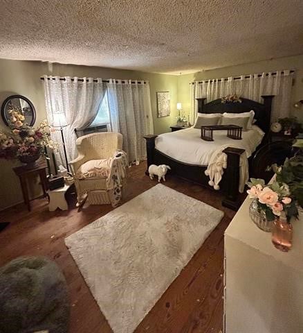 bedroom featuring a textured ceiling and dark hardwood / wood-style flooring