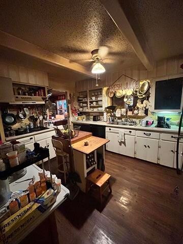 kitchen featuring a textured ceiling, white cabinetry, ceiling fan, beam ceiling, and dark hardwood / wood-style floors