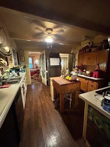 kitchen with beamed ceiling, dark wood-type flooring, ceiling fan, and sink