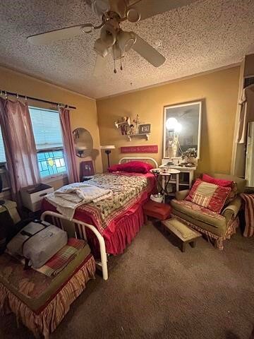 bedroom with a textured ceiling, carpet floors, and ceiling fan