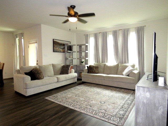 living room with ceiling fan and dark wood-type flooring