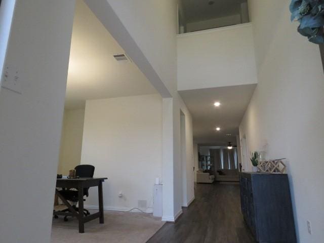 hall featuring dark hardwood / wood-style flooring and a high ceiling