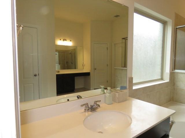 bathroom with vanity and a shower with shower door