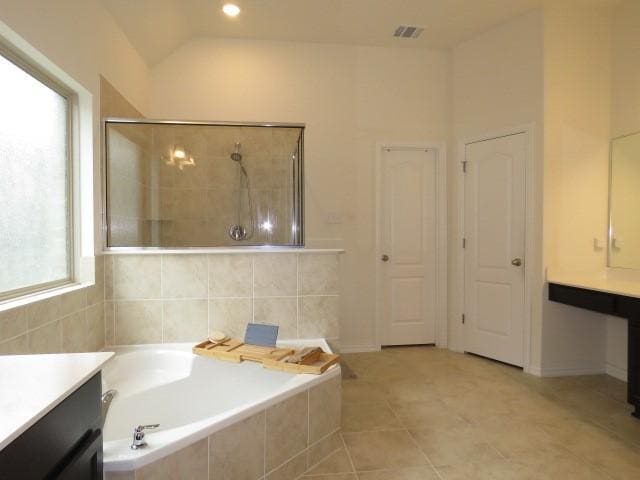 bathroom featuring separate shower and tub, plenty of natural light, vanity, and lofted ceiling