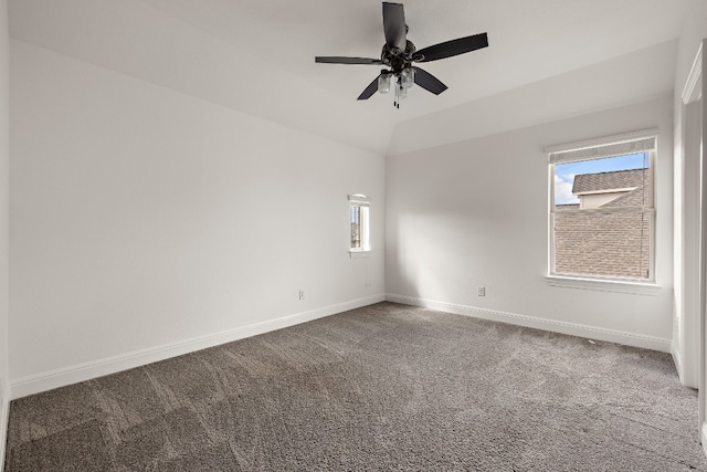 carpeted spare room with ceiling fan and vaulted ceiling