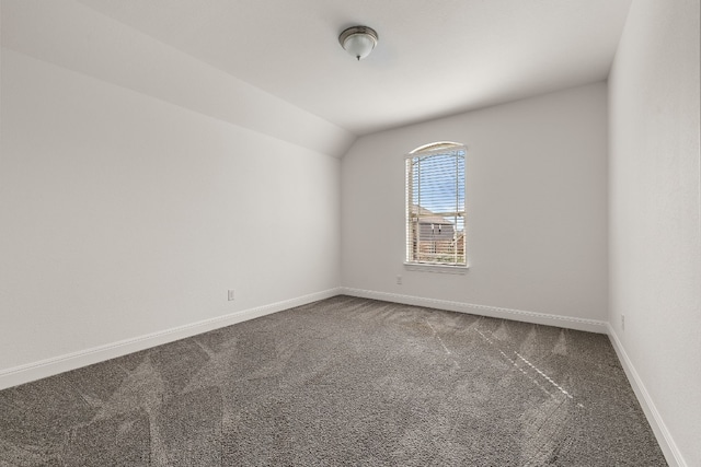 carpeted empty room with lofted ceiling