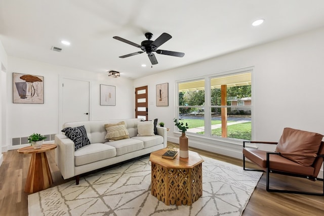 living room with hardwood / wood-style flooring and ceiling fan