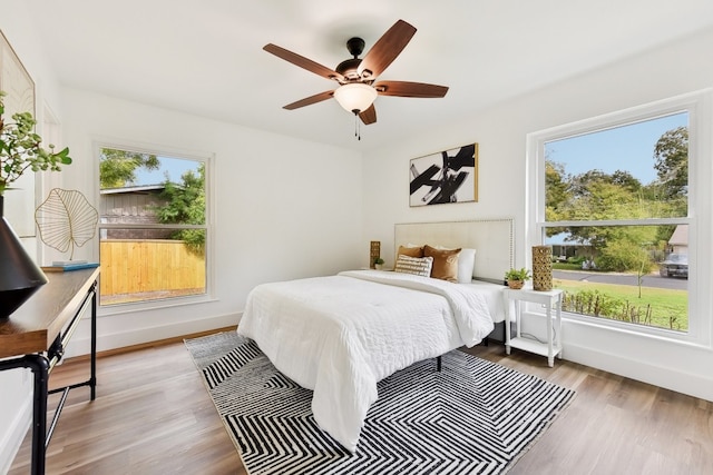 bedroom with light hardwood / wood-style floors, multiple windows, and ceiling fan