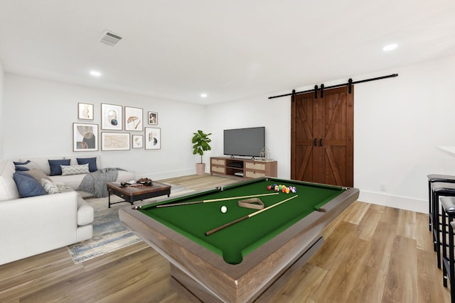 rec room with wood-type flooring, billiards, and a barn door