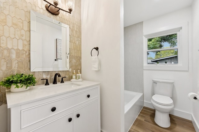 bathroom with toilet, decorative backsplash, hardwood / wood-style floors, and vanity