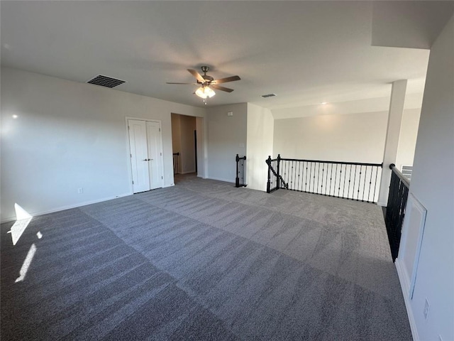 carpeted spare room featuring ceiling fan