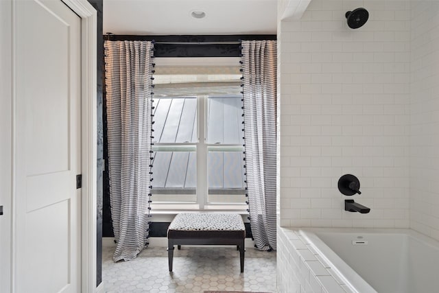 bathroom with tiled shower / bath combo and tile patterned flooring