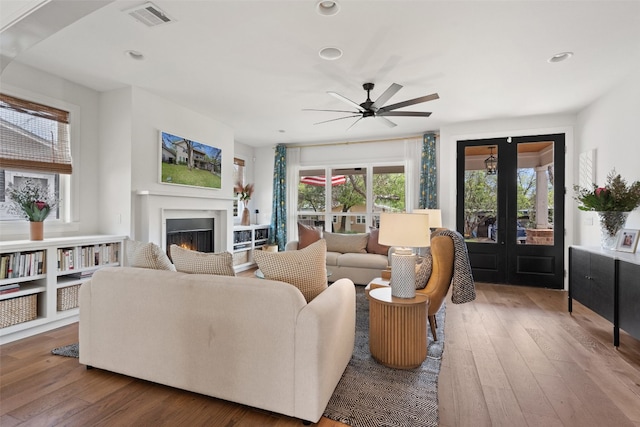 living room featuring wood-type flooring, plenty of natural light, and ceiling fan