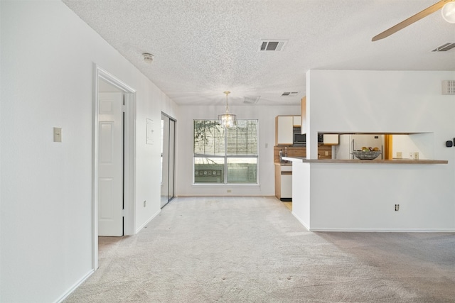 kitchen featuring hanging light fixtures, light carpet, a textured ceiling, and ceiling fan