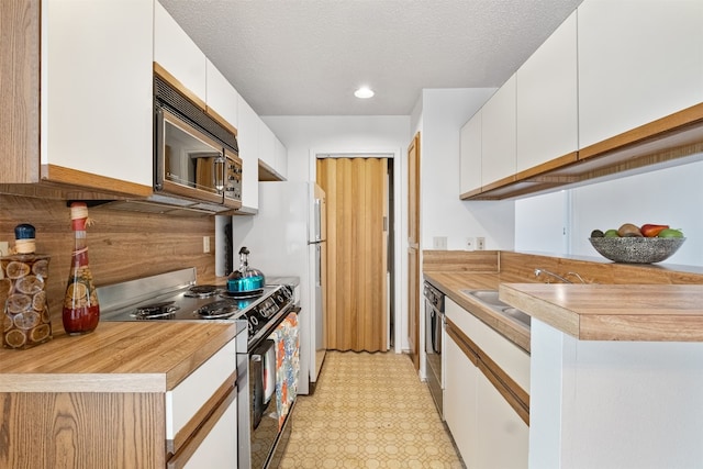 kitchen featuring white cabinetry, stainless steel appliances, a textured ceiling, and sink