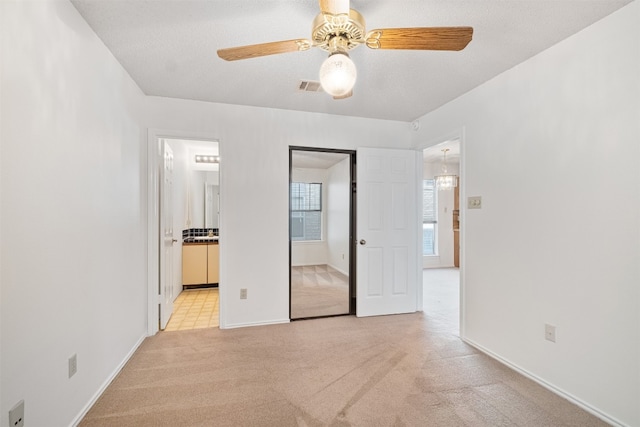 carpeted empty room featuring a textured ceiling and ceiling fan