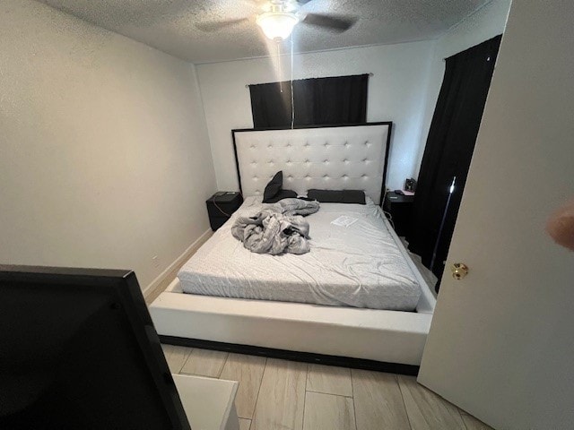 bedroom featuring ceiling fan, a textured ceiling, and light hardwood / wood-style flooring