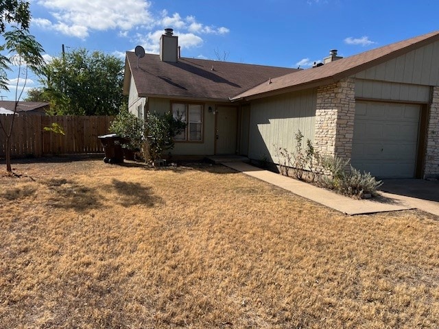 single story home with a garage and a front lawn