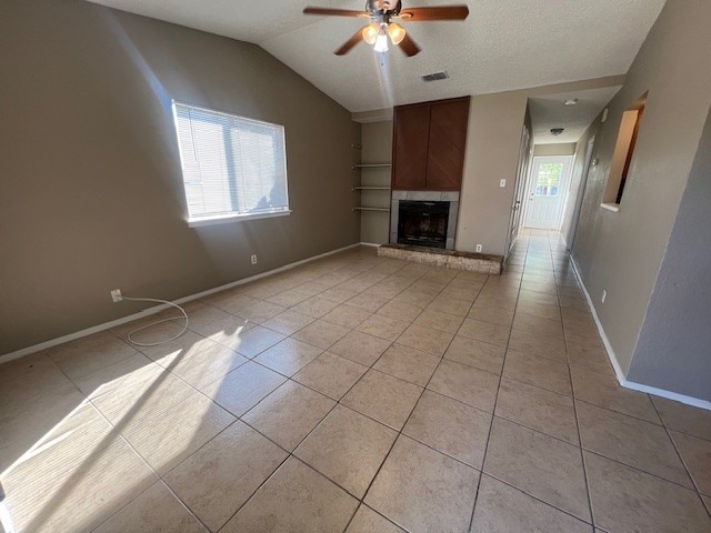 unfurnished living room featuring vaulted ceiling, light tile patterned floors, and ceiling fan