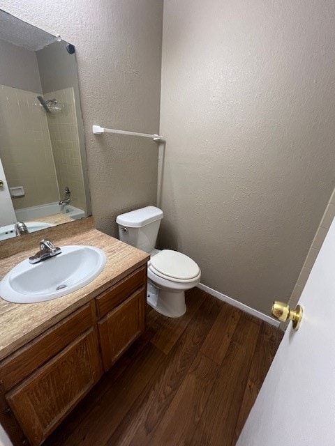 full bathroom with vanity, toilet, shower / bathtub combination, and hardwood / wood-style floors