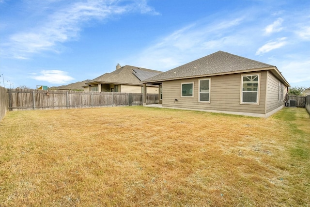 back of property featuring central air condition unit and a lawn