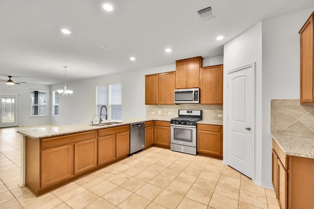 kitchen featuring backsplash, appliances with stainless steel finishes, sink, and kitchen peninsula