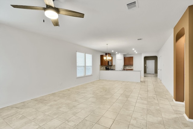 unfurnished living room featuring light tile patterned flooring and ceiling fan with notable chandelier