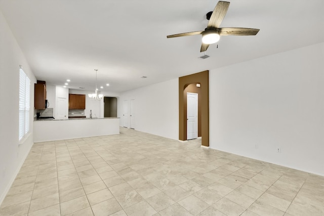 unfurnished living room with light tile patterned flooring and ceiling fan with notable chandelier