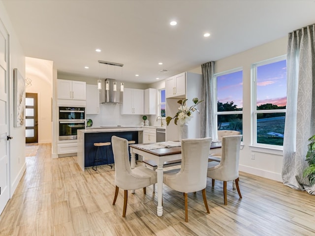 dining room featuring sink and light wood-type flooring