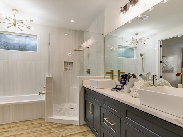 570 Quick Draw, Horseshoe Bay, TX 78657 - bathroom featuring a chandelier, walk in shower, a bath, double vanity, and wood finished floors