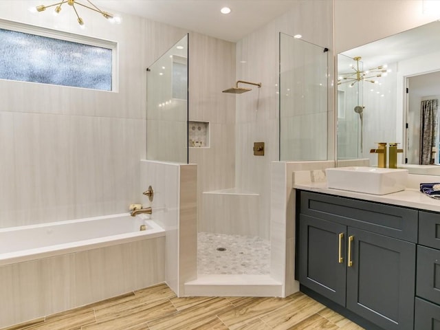570 Quick Draw, Horseshoe Bay, TX 78657 - full bathroom featuring a chandelier, a walk in shower, a garden tub, and vanity