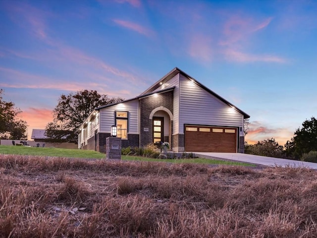 570 Quick Draw, Horseshoe Bay, TX 78657 - mid-century inspired home with a garage, driveway, and brick siding