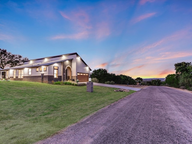 view of front of house featuring a garage and a lawn