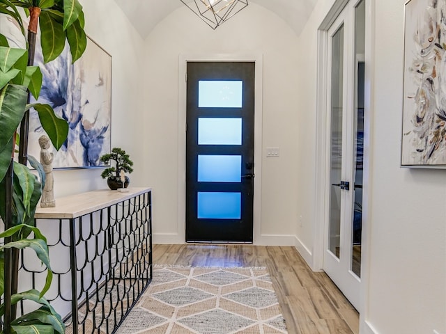 foyer entrance featuring vaulted ceiling and light hardwood / wood-style flooring