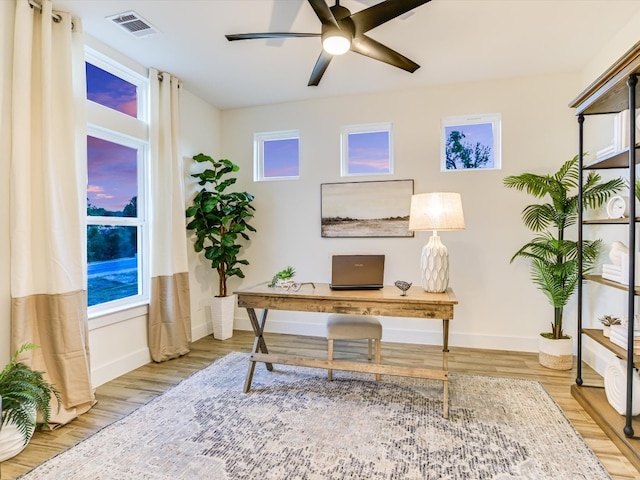 office with light hardwood / wood-style floors and ceiling fan