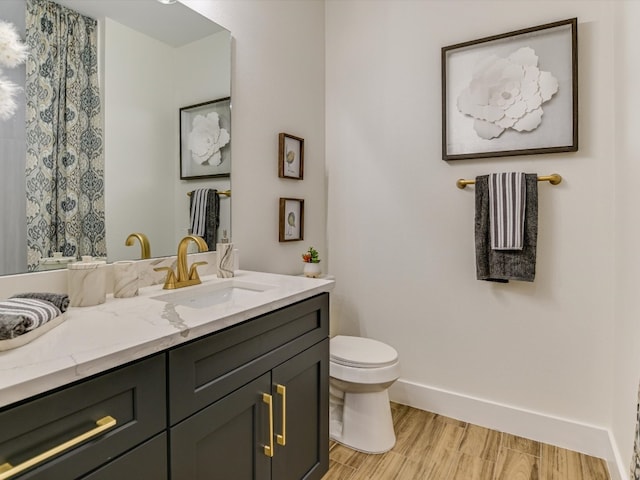 bathroom featuring vanity, hardwood / wood-style flooring, and toilet