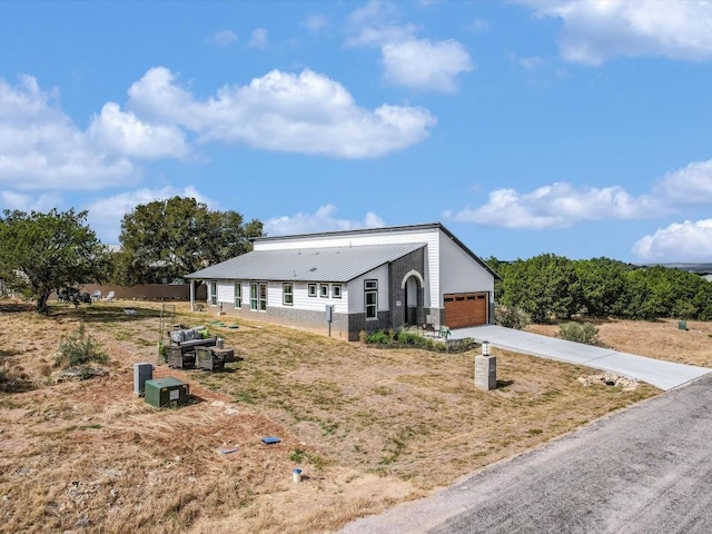 570 Quick Draw, Horseshoe Bay, TX 78657 - view of front of home featuring driveway, a garage, and metal roof