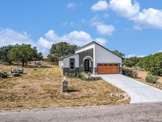 570 Quick Draw, Horseshoe Bay, TX 78657 - view of front of house featuring a garage, driveway, a front lawn, and brick siding