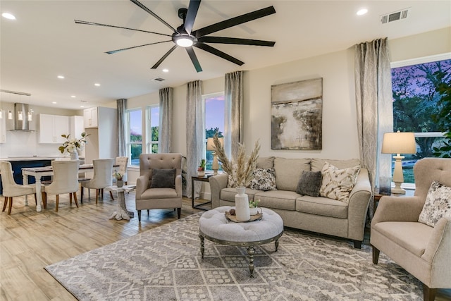 living room featuring light wood-type flooring and ceiling fan