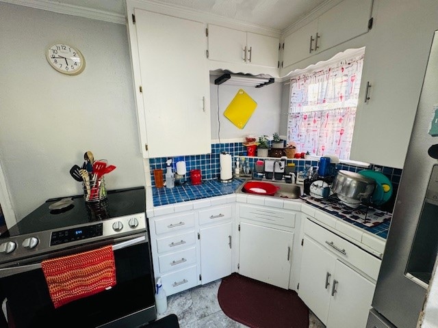 kitchen with tile countertops, appliances with stainless steel finishes, sink, and white cabinets