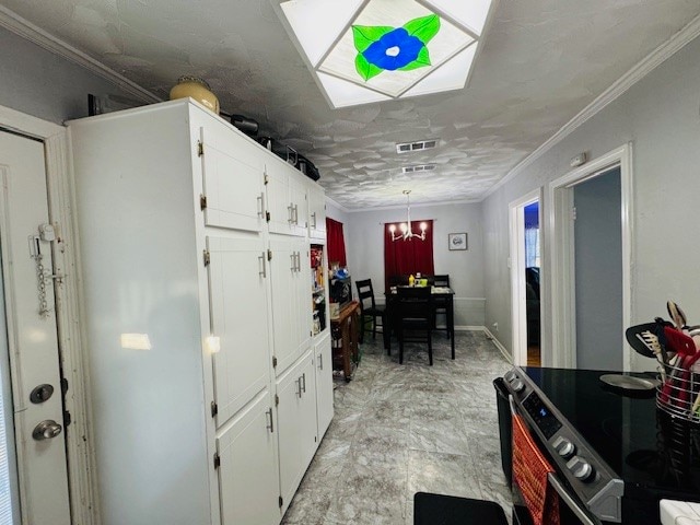 kitchen featuring crown molding, white cabinets, a chandelier, and electric stove