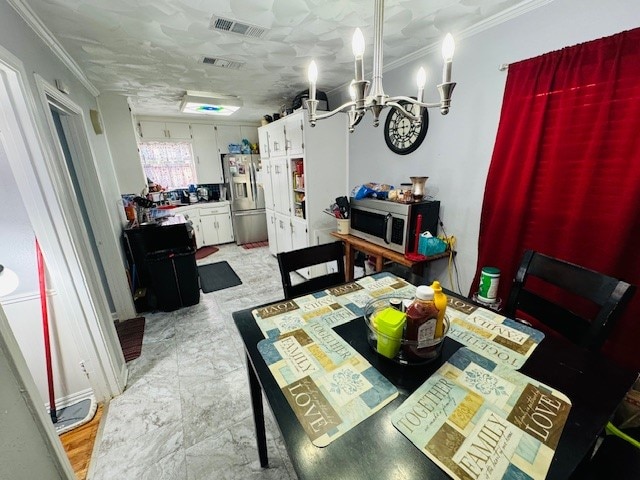 dining room with crown molding and a notable chandelier