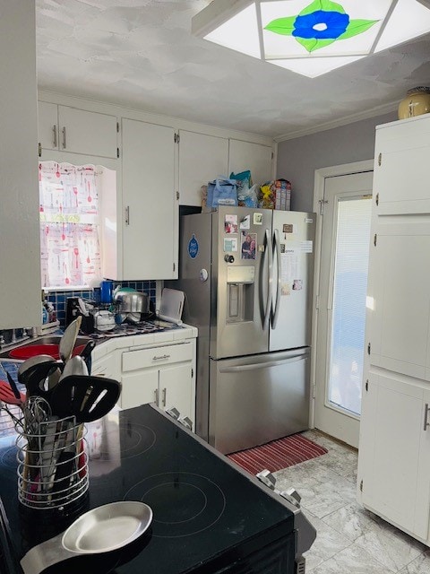 kitchen featuring crown molding, white cabinets, and stainless steel appliances